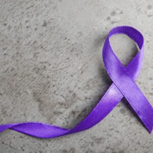 Laço roxo/violeta representa a luta contra a violência e o feminicídio